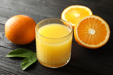 Photo of Glass with orange juice and fresh fruit on wooden background