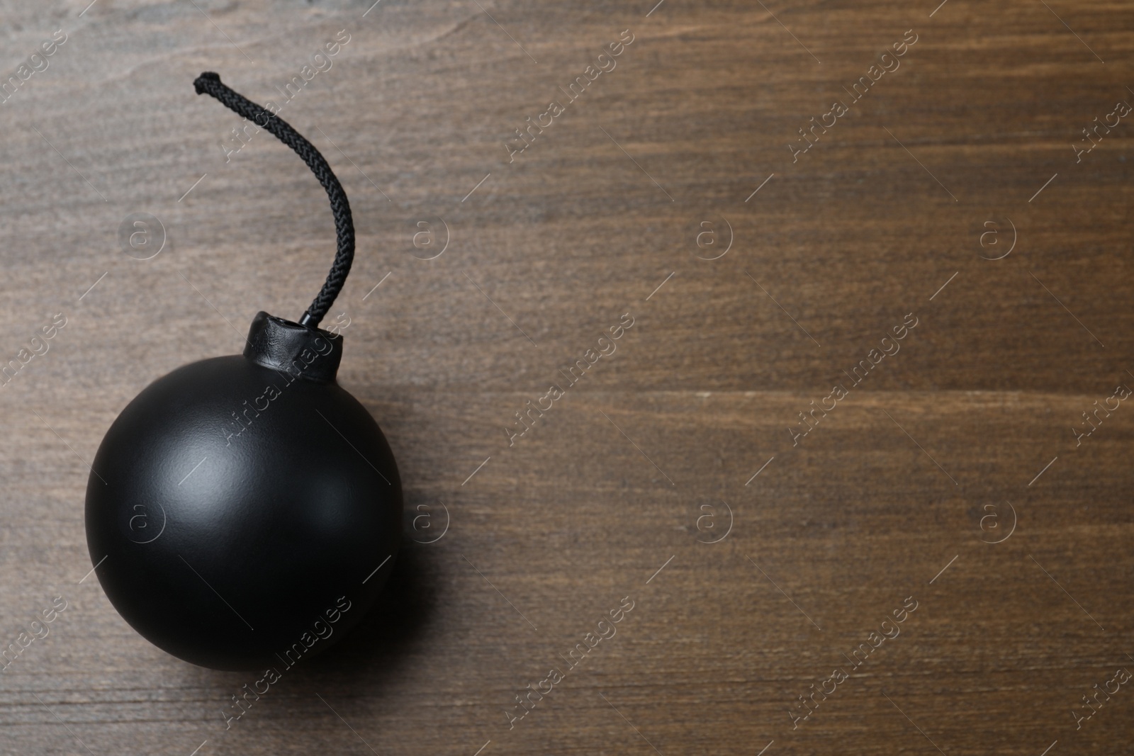 Photo of Old fashioned fuse bomb on wooden table, top view. Space for text