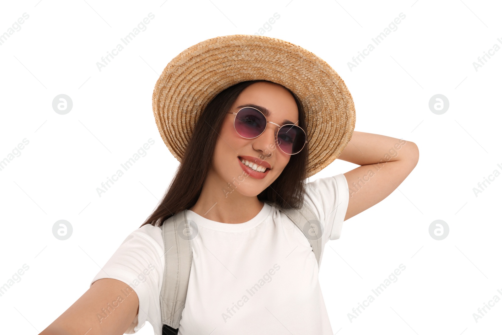 Photo of Smiling young woman in sunglasses and straw hat taking selfie on white background