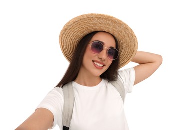 Smiling young woman in sunglasses and straw hat taking selfie on white background