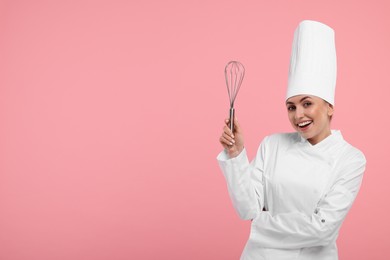 Photo of Happy professional confectioner in uniform holding whisk on pink background. Space for text