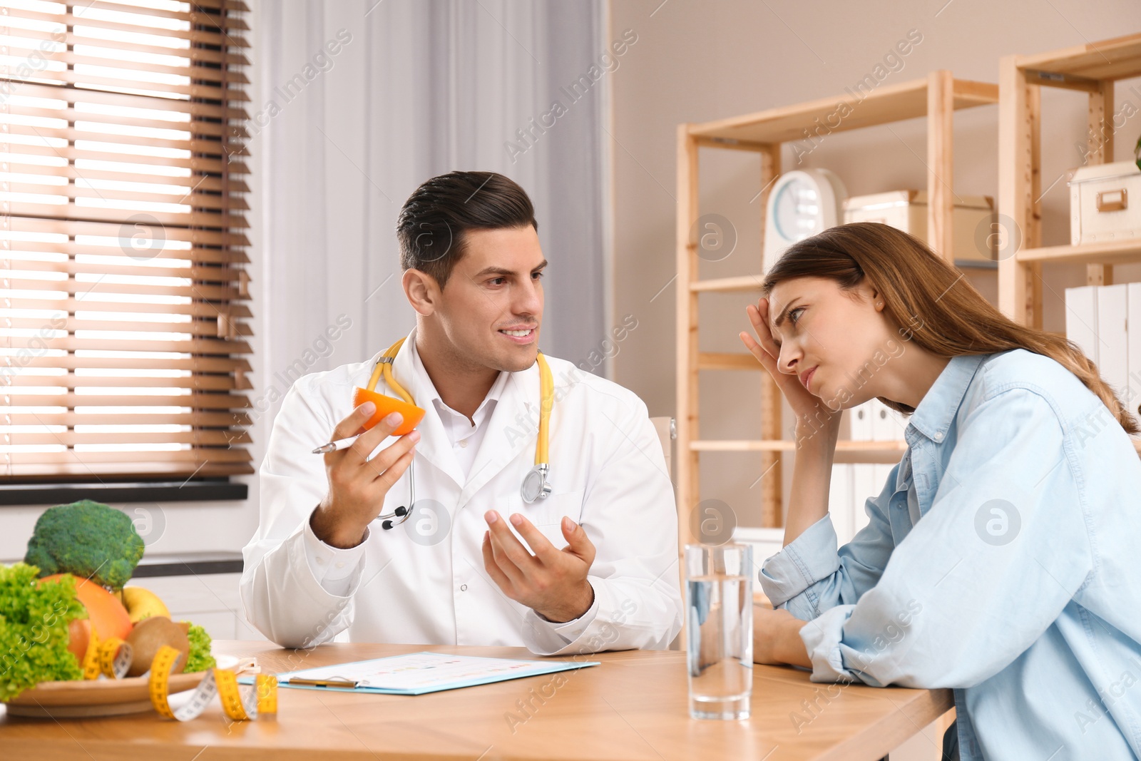 Photo of Nutritionist consulting patient at table in clinic