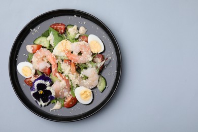 Photo of Delicious Caesar salad with shrimps on grey background, top view. Space for text
