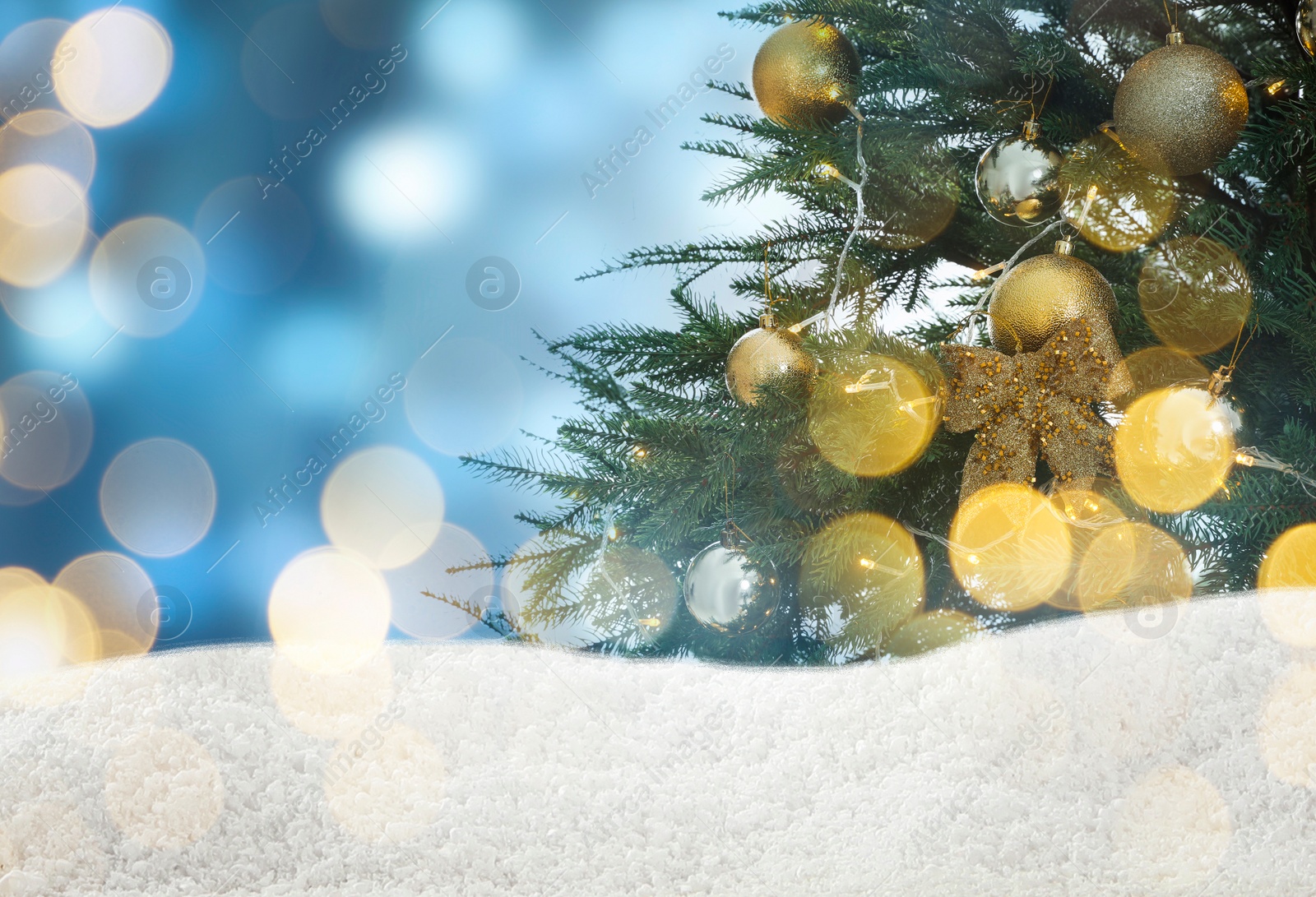 Image of Beautifully decorated Christmas tree and snow on light blue background, space for text. Bokeh effect