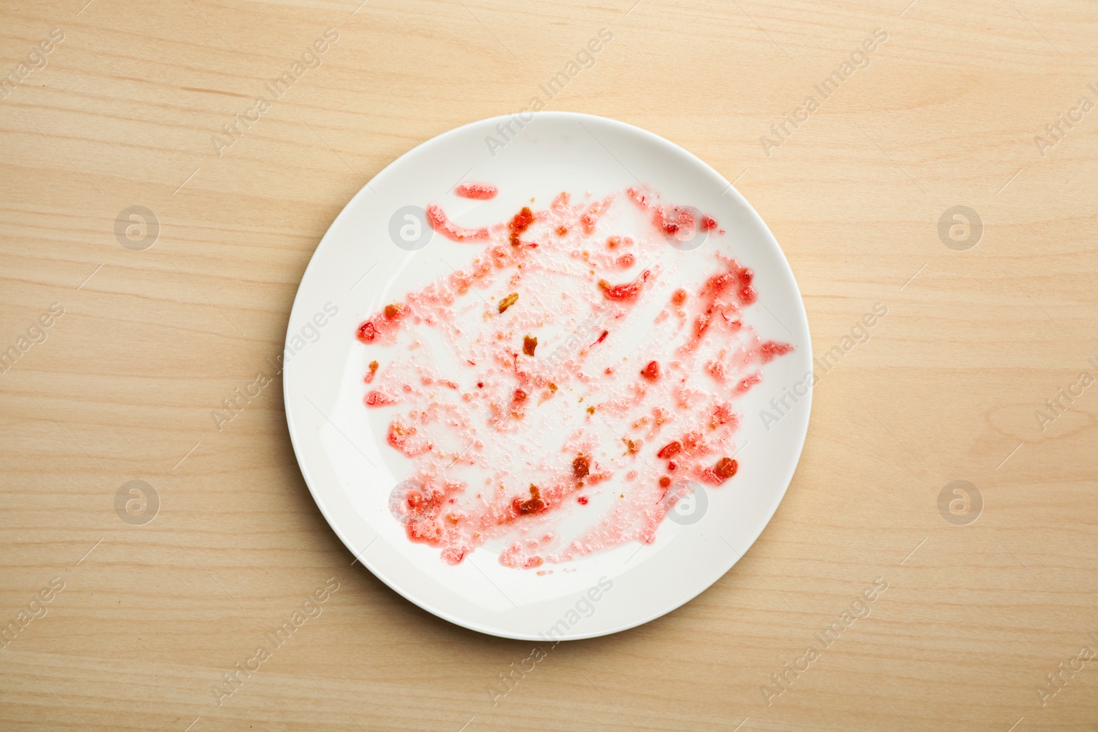 Photo of Dirty plate with food leftovers on wooden background, top view