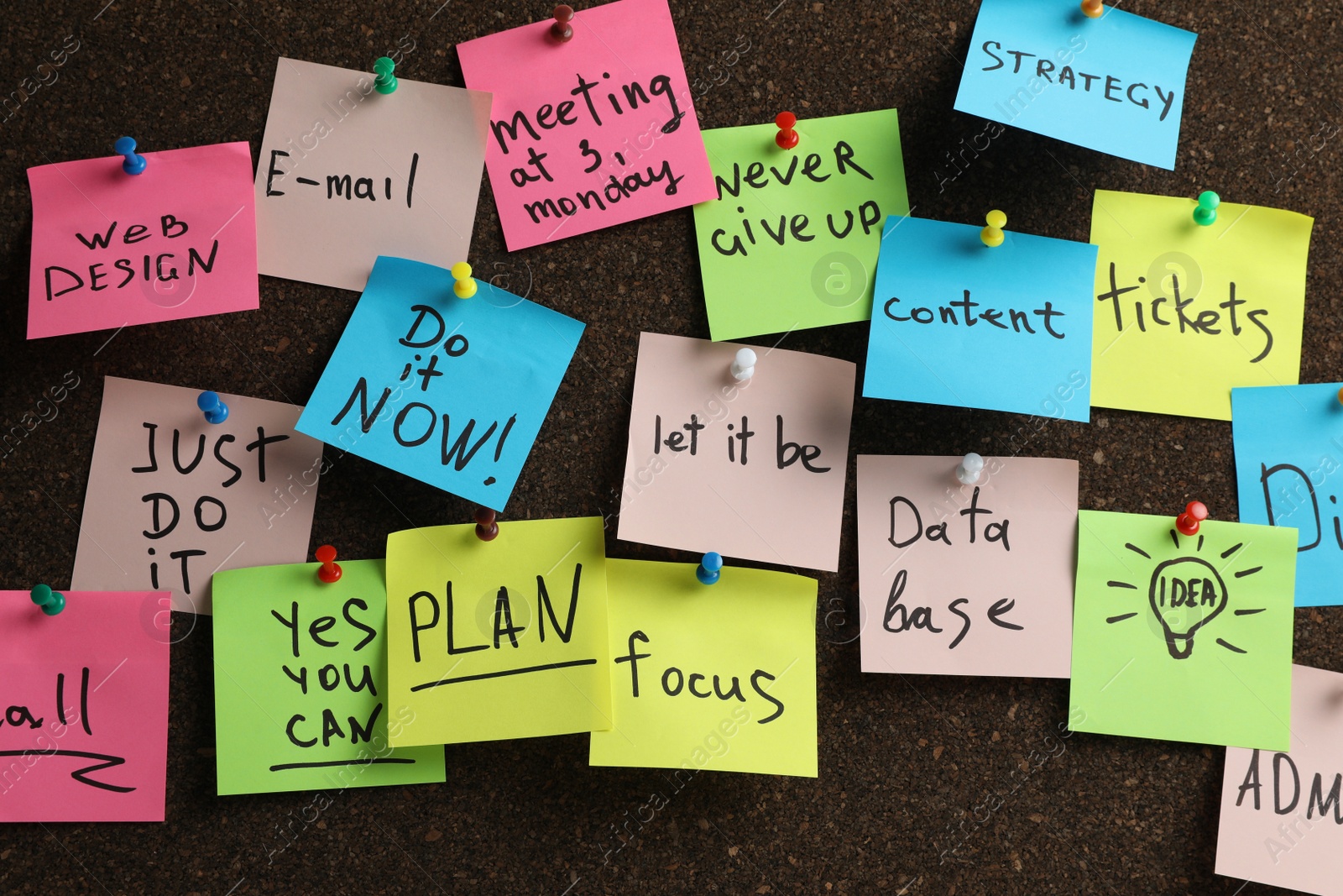 Photo of Colorful reminder notes pinned to cork board