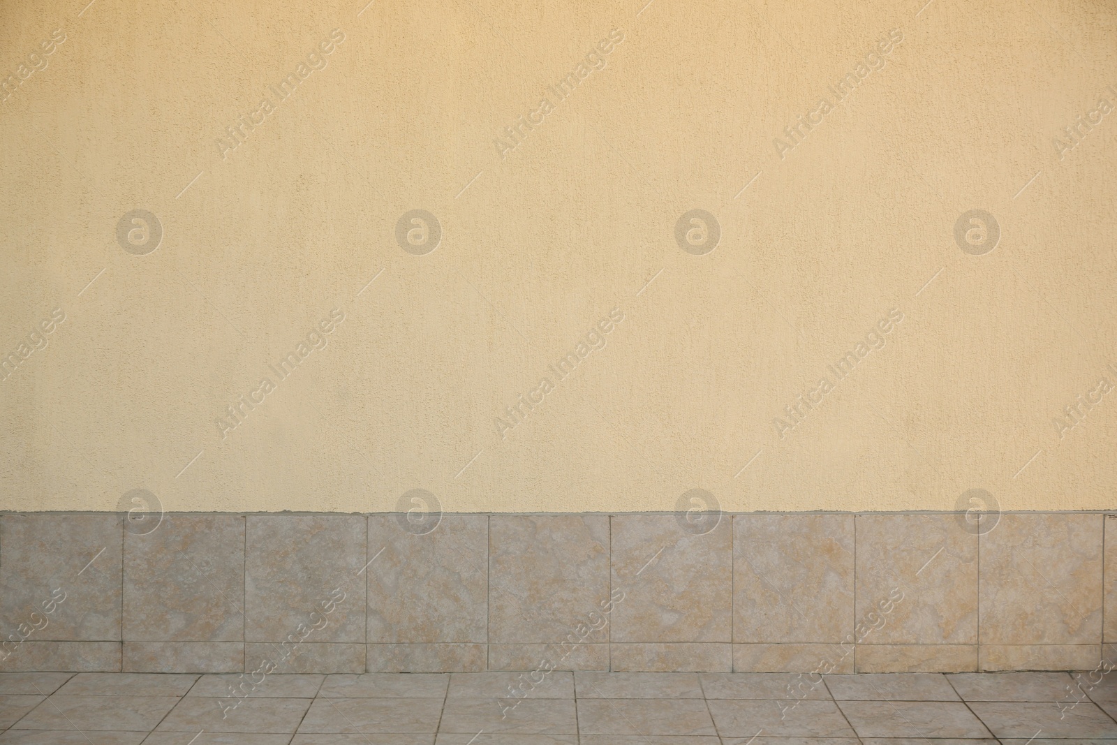 Photo of View on urban beige concrete wall and street tiles