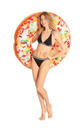 Beautiful young woman in stylish bikini with doughnut inflatable ring on white background