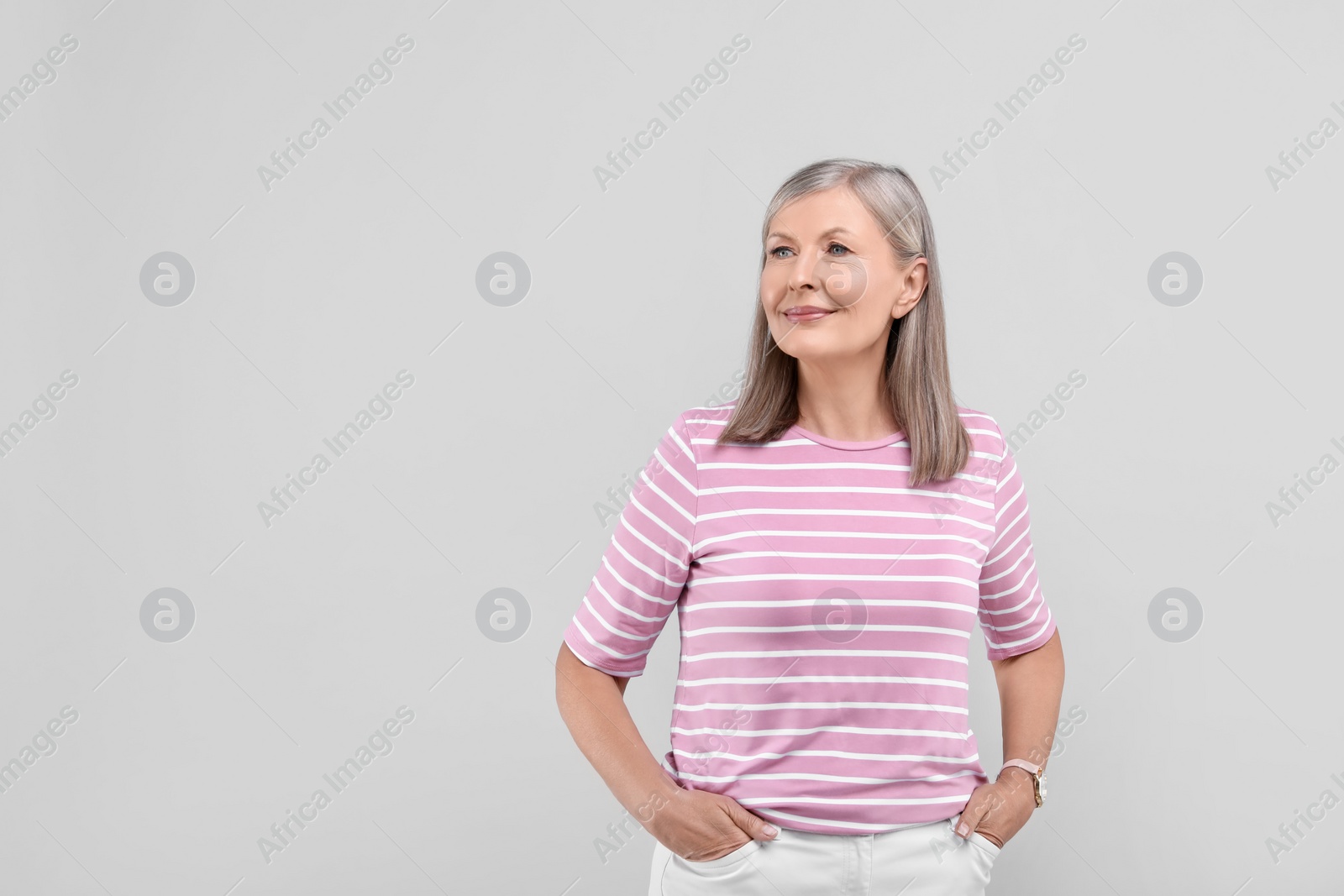 Photo of Portrait of beautiful senior woman on light grey background. Space for text