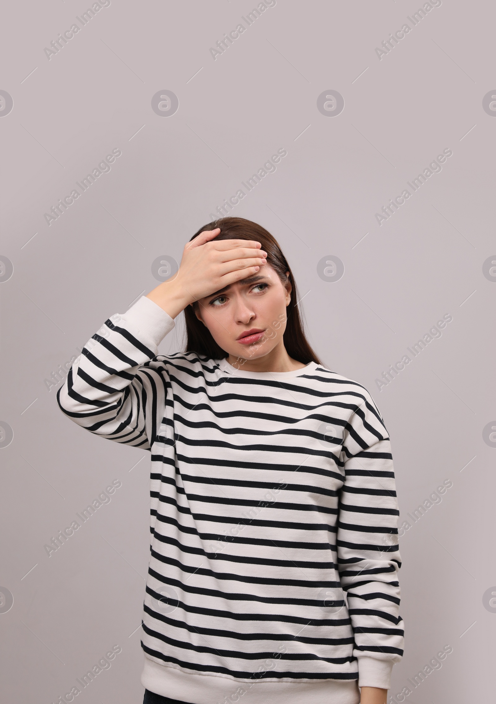 Photo of Woman suffering from headache on light grey background. Cold symptoms