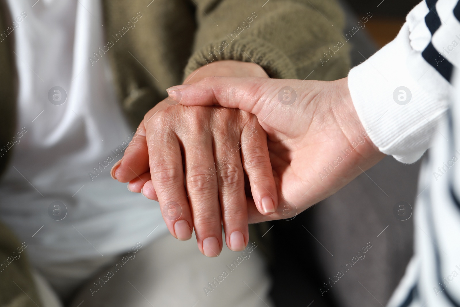 Photo of Caregiver helping elderly woman at home, closeup