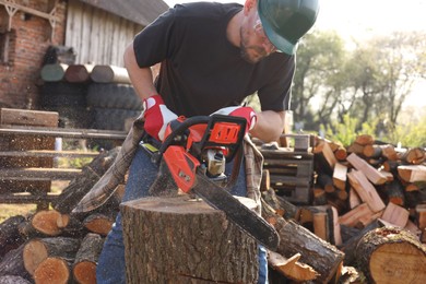 Man sawing wooden log on sunny day