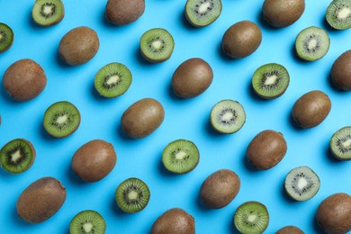 Many cut and whole fresh ripe kiwis on light blue background, flat lay