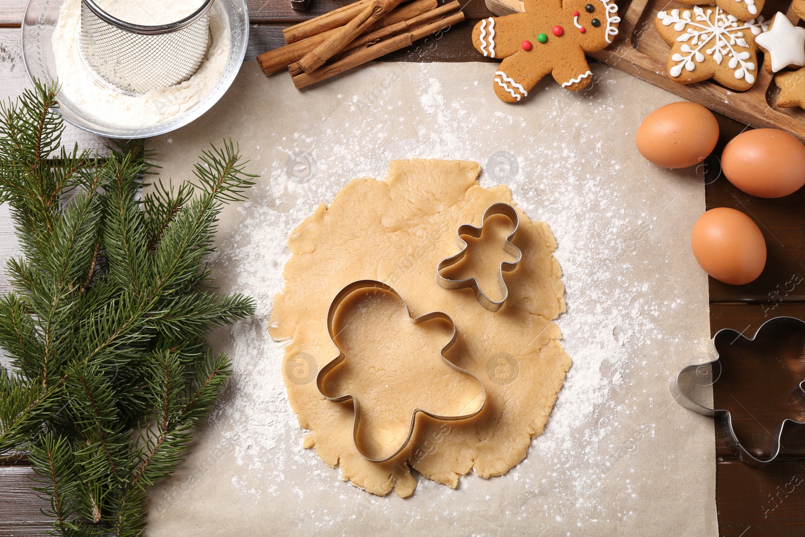 Photo of Making Christmas cookies. Flat lay composition with ingredients and raw dough on wooden table