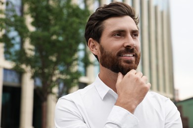Photo of Portrait of handsome bearded man on city street, space for text