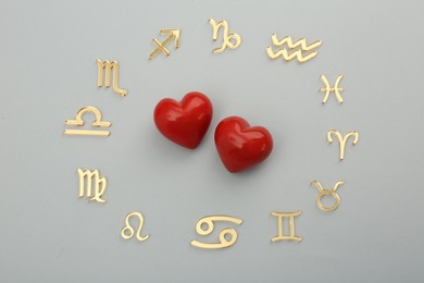 Photo of Zodiac signs and red hearts on grey background, flat lay