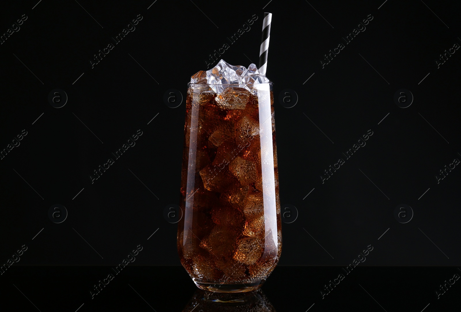 Photo of Glass of refreshing soda water with ice cubes on black background