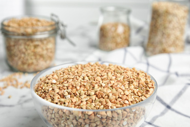 Uncooked green buckwheat grains on white table