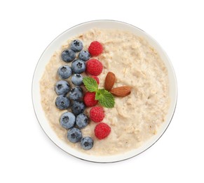 Photo of Tasty oatmeal porridge with raspberries, blueberries and almond nuts in bowl on white background, top view