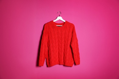 Photo of Hanger with stylish sweater on color background