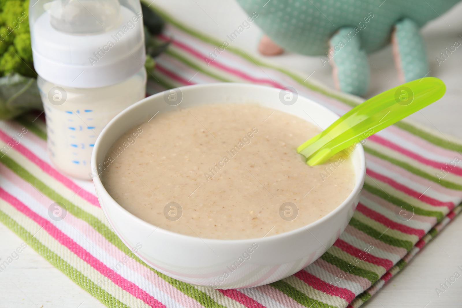 Photo of Bowl with healthy baby food on light table