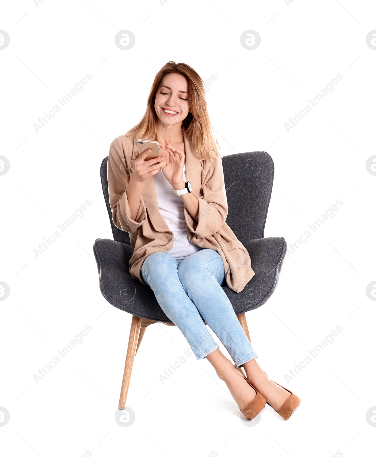 Photo of Young woman with smartphone sitting in armchair on white background