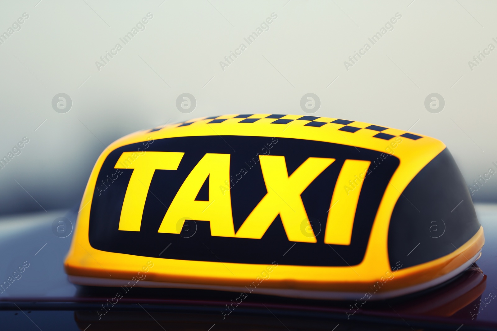 Photo of Taxi car with yellow roof sign outdoors, closeup