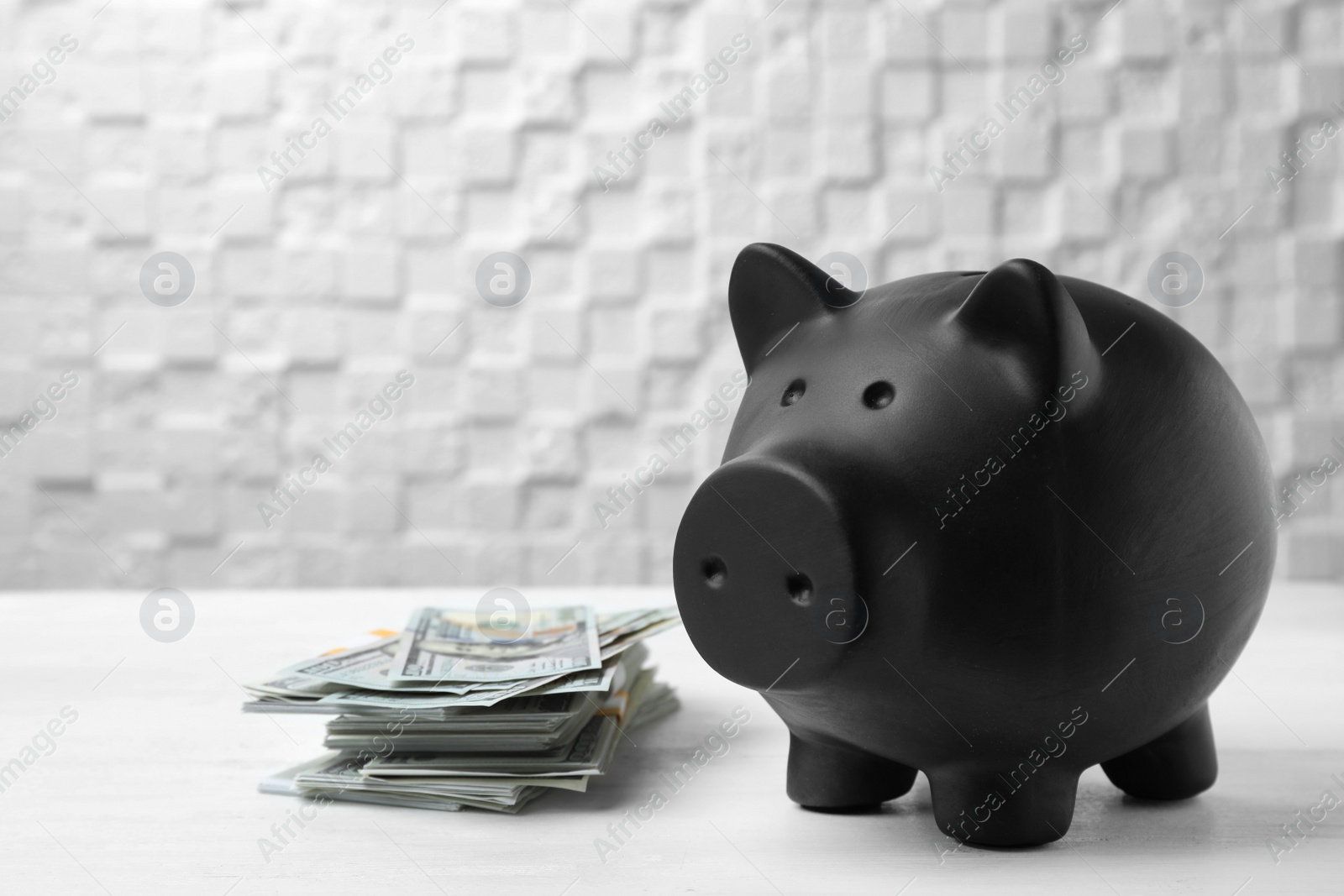 Photo of Black piggy bank and money on table