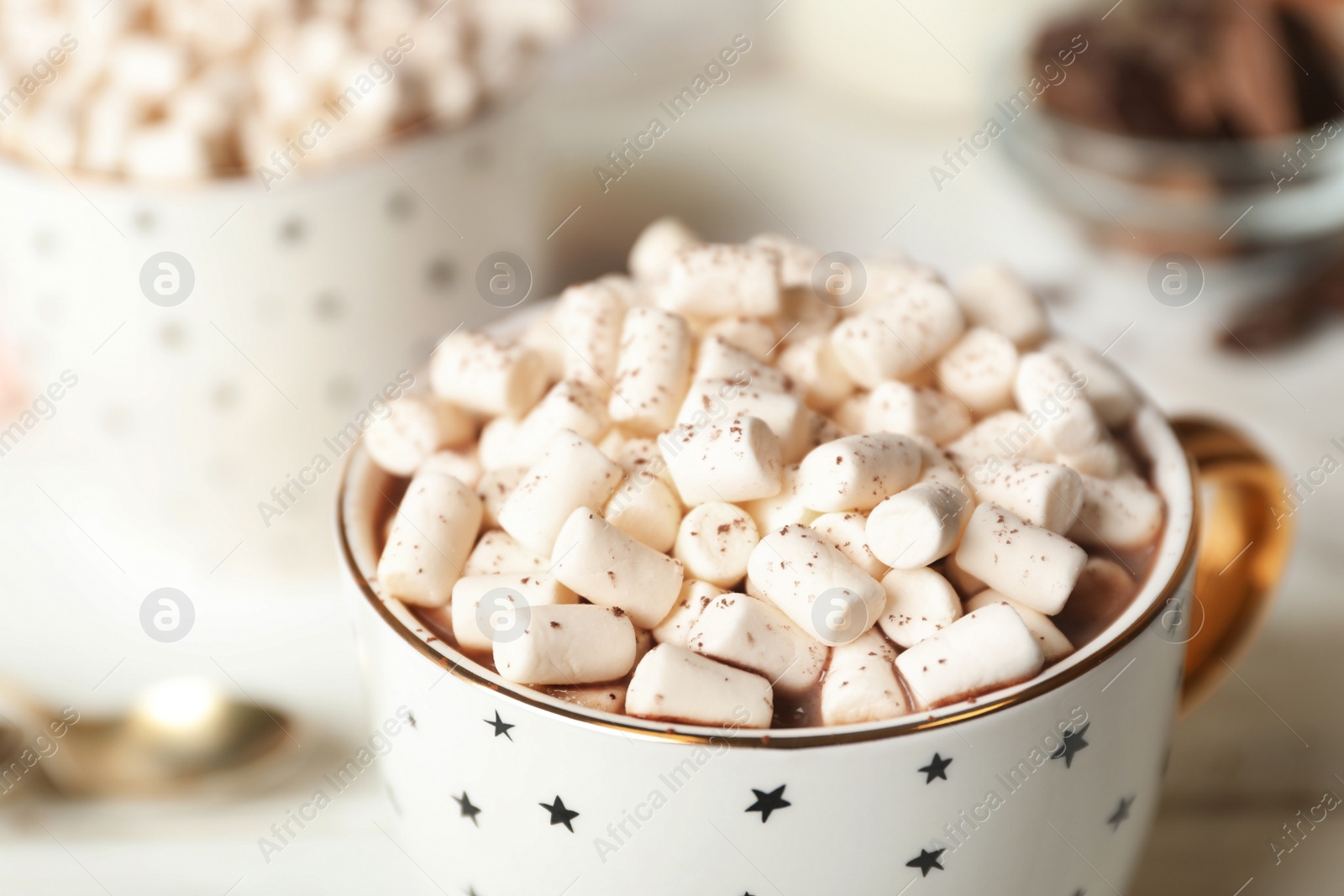 Photo of Delicious cocoa drink with marshmallows in cup on table, closeup