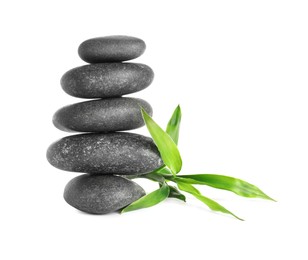 Photo of Stack of spa stones and bamboo sprout on white background