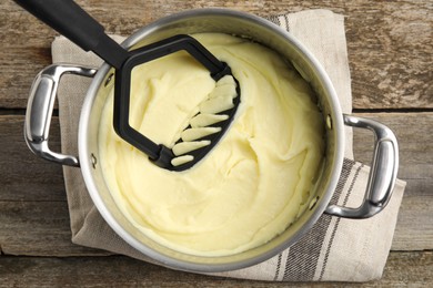 Photo of Pot of freshly cooked homemade mashed potatoes on wooden table, top view