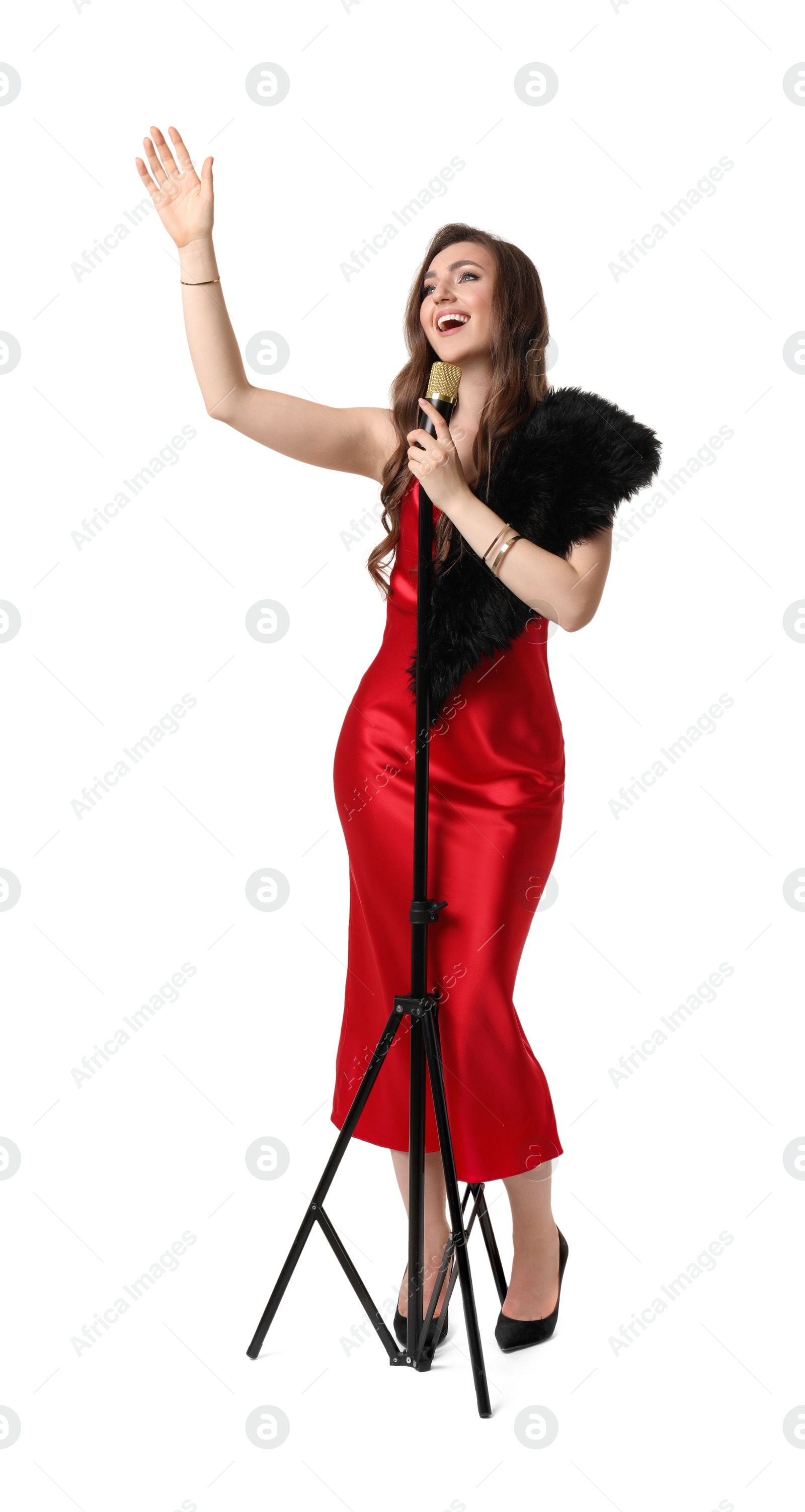 Photo of Beautiful young woman in stylish red dress with microphone singing on white background