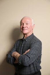 Portrait of elderly man on color background