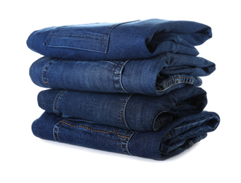 Photo of Stack of different jeans isolated on white