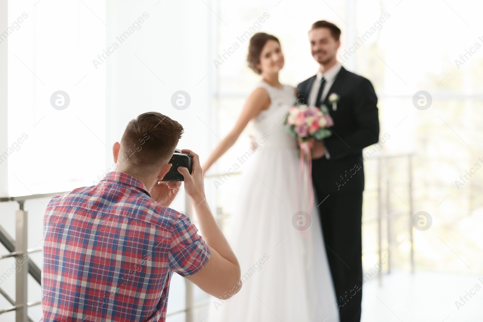 Photo of Professional photographer taking photo of wedding couple in studio