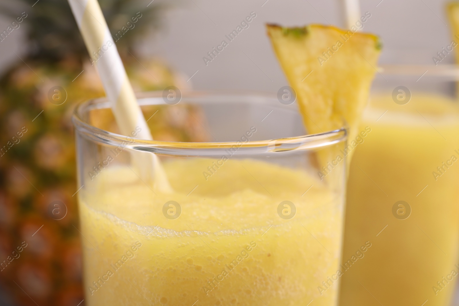 Photo of Tasty pineapple smoothie and fresh fruit on light background, closeup