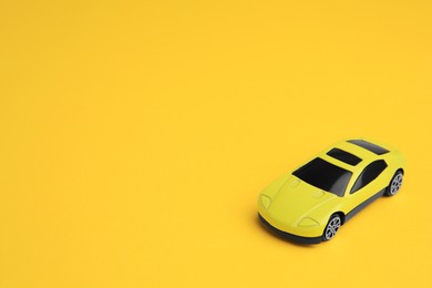 One bright car on yellow background, space for text. Children`s toy