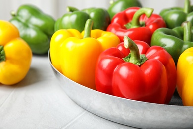 Dish with ripe paprika peppers on table