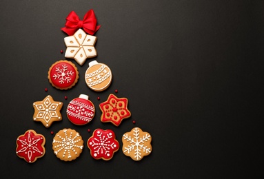 Photo of Christmas tree shape made of tasty homemade cookies on black background, flat lay. Space for text