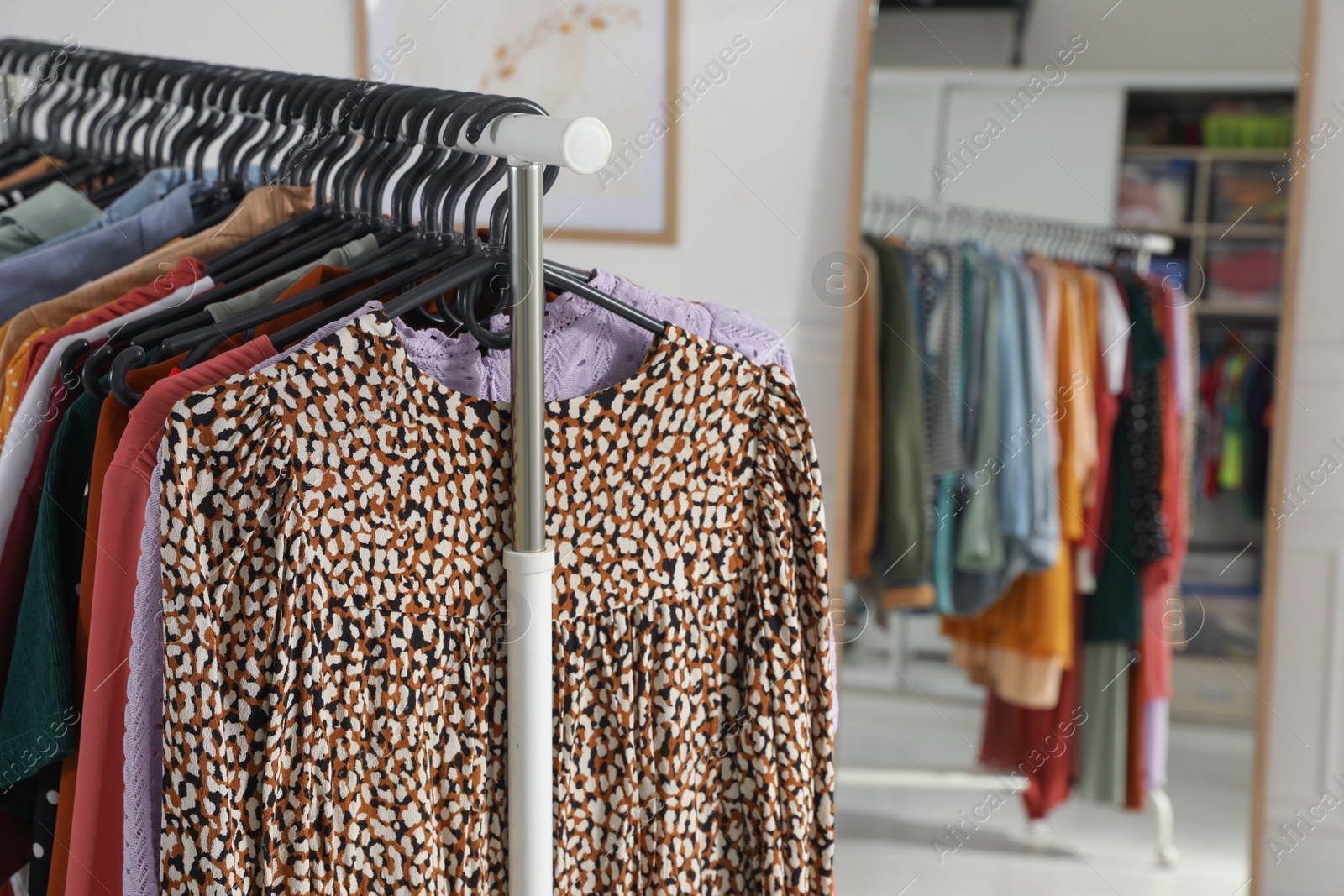 Photo of Rack with stylish clothes indoors. Fast fashion