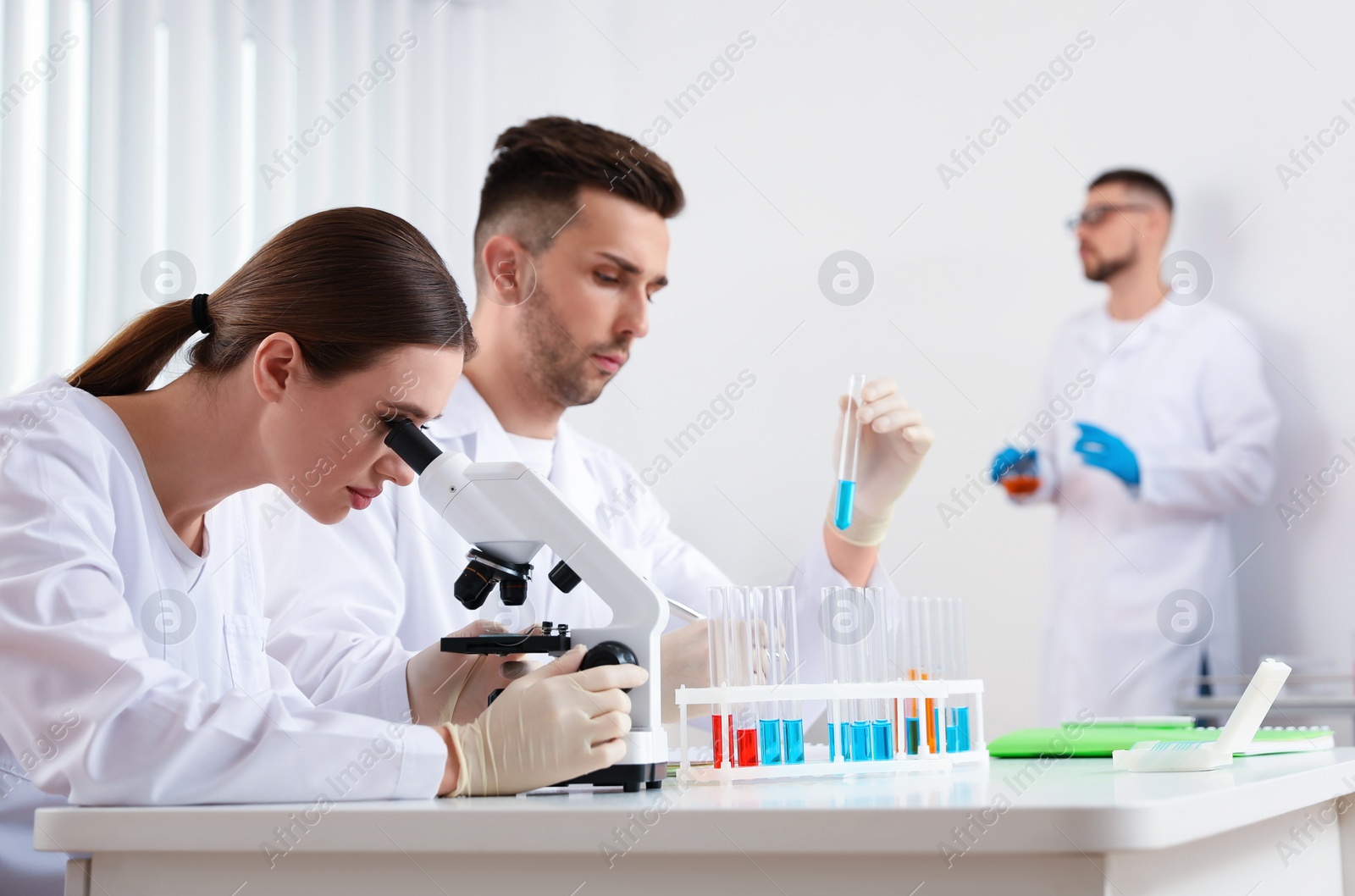 Photo of Medical students with microscope in modern laboratory