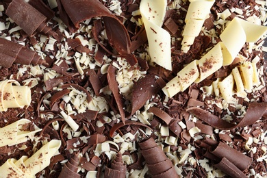 Photo of Yummy chocolate curls for decor as background, top view