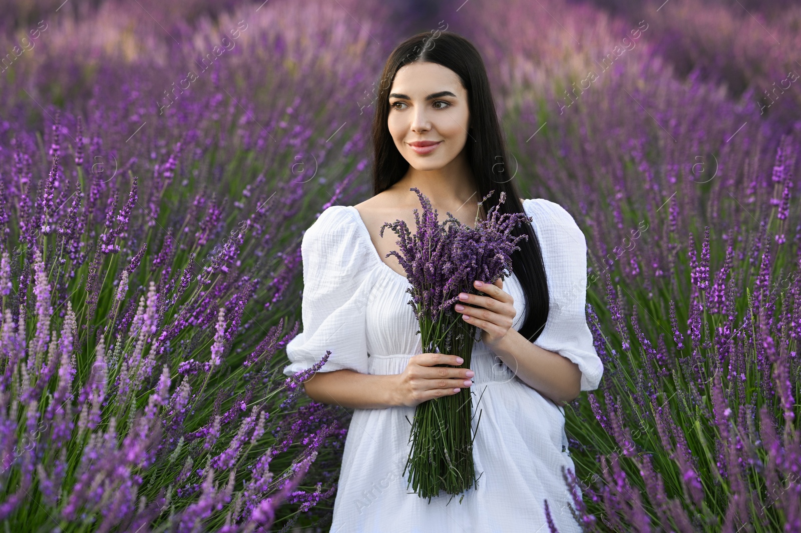 Photo of Beautiful young woman with bouquet in lavender field