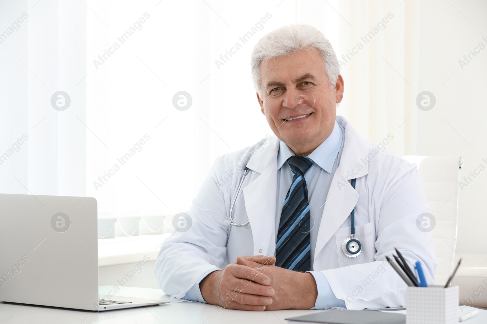 Photo of Portrait of senior doctor in white coat at workplace