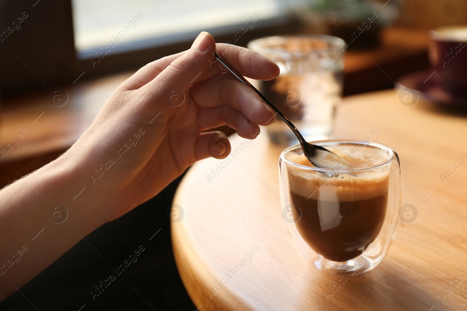 Photo of Woman with aromatic coffee at table in cafe, closeup