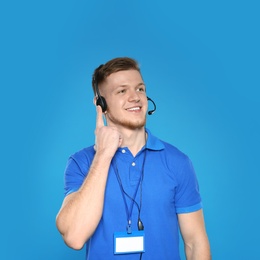 Portrait of technical support operator with headset on color background