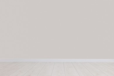 Photo of Empty room with white wall and wooden floor