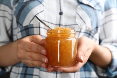 Photo of Woman with jar of delicious pear jam, closeup