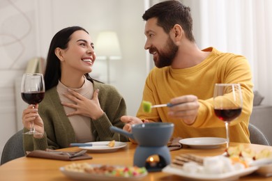 Affectionate couple enjoying fondue during romantic date at home