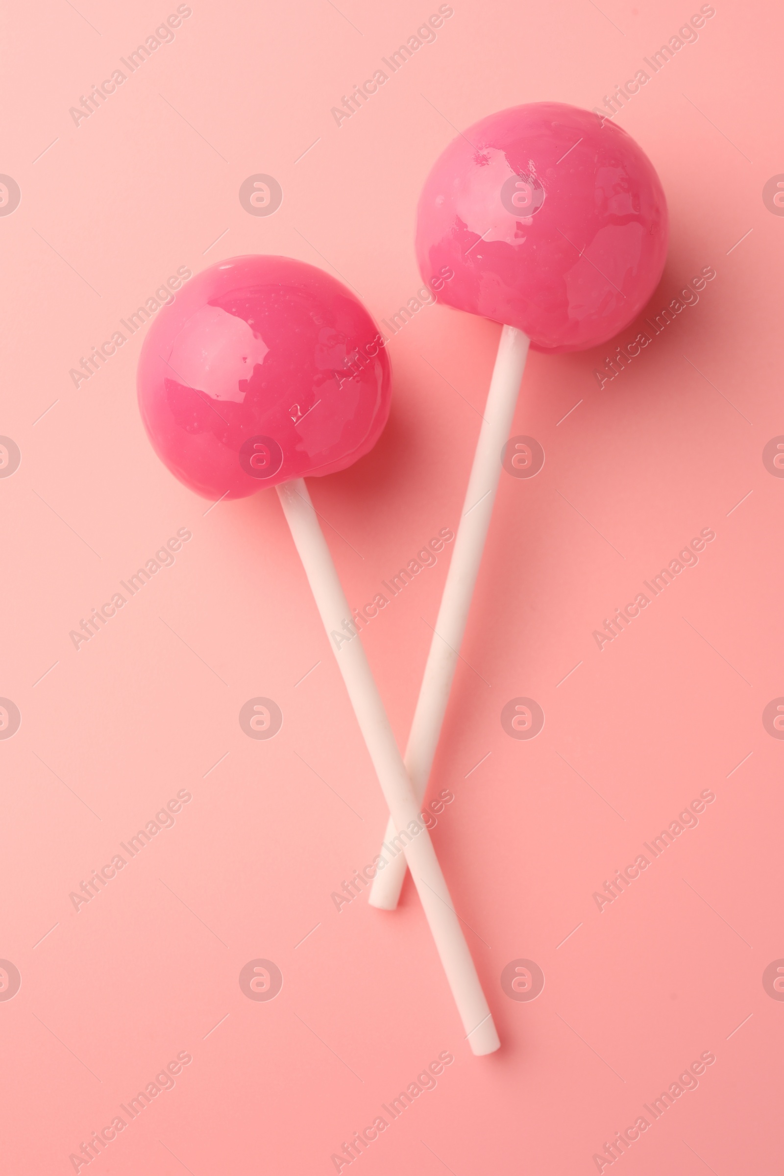 Photo of Tasty lollipops on pink background, flat lay